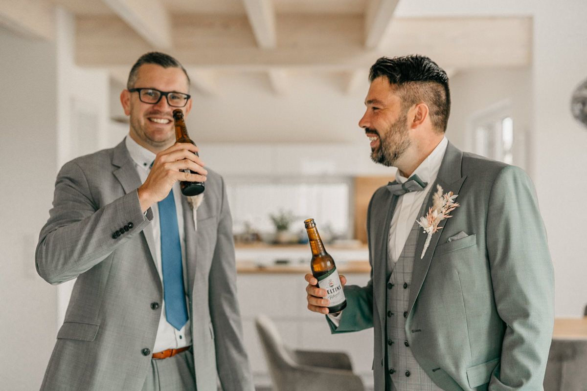 two men in suits holding bottles