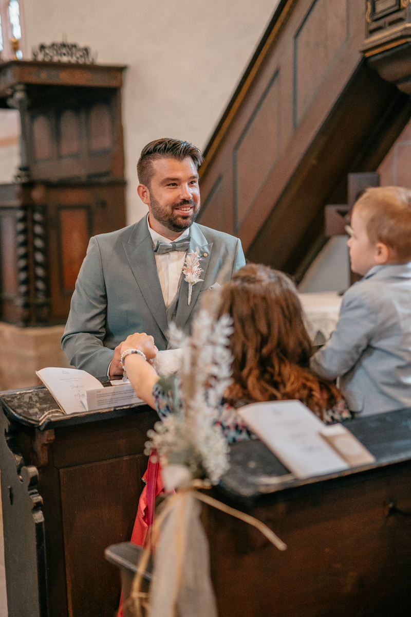 a man in a suit and bow tie standing at a reception desk