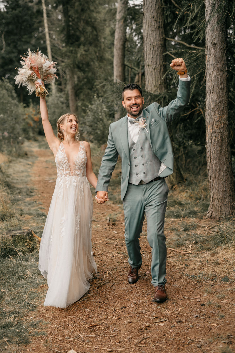 a groom and his bride holding hands and smiling