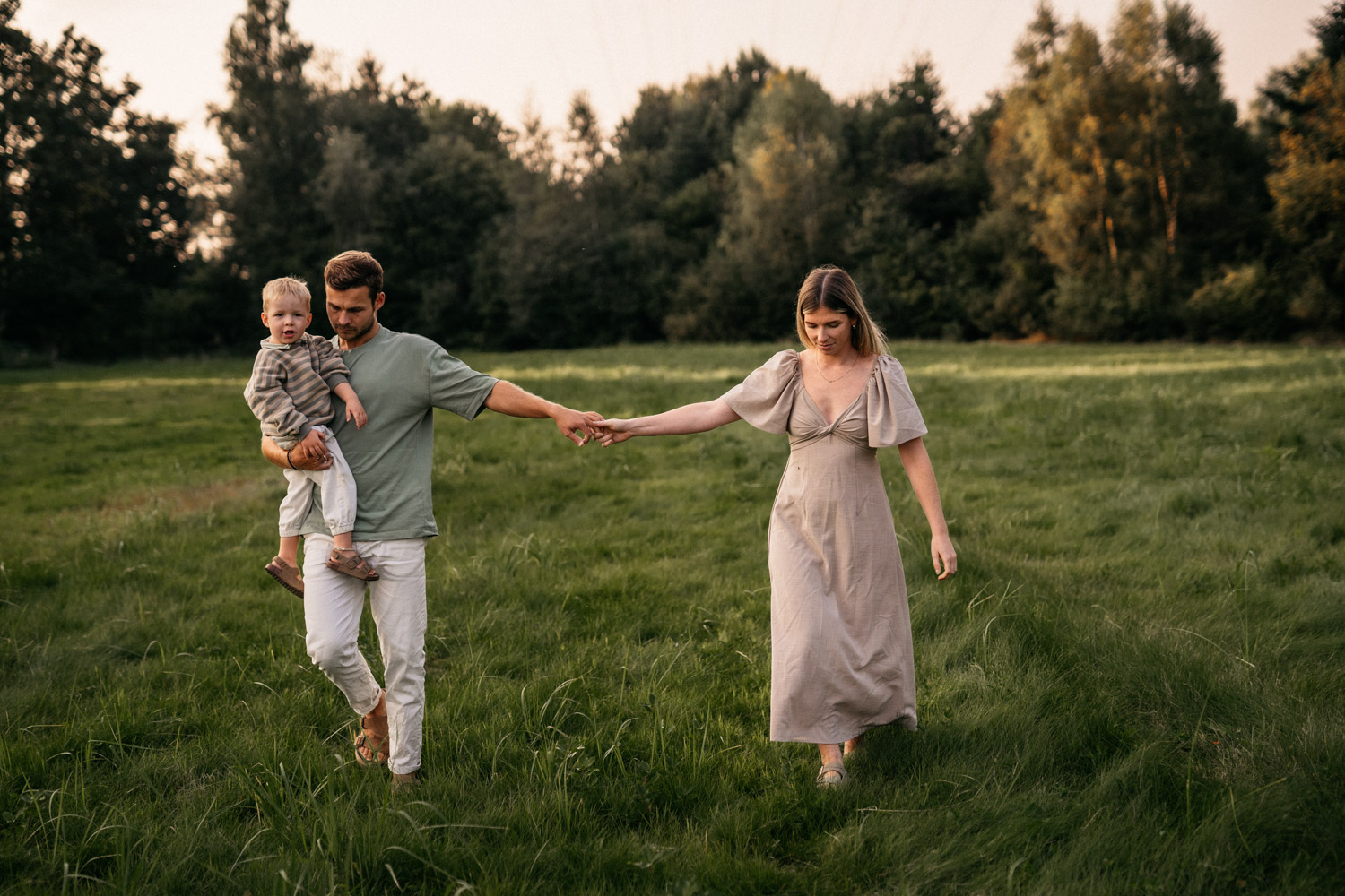 a man holding a child in a field