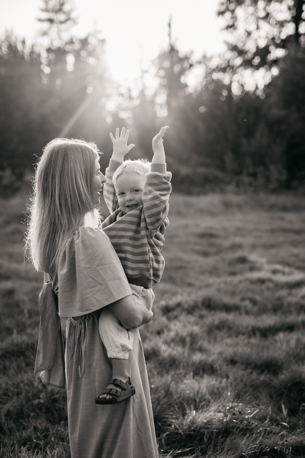 a woman holding a baby in a field