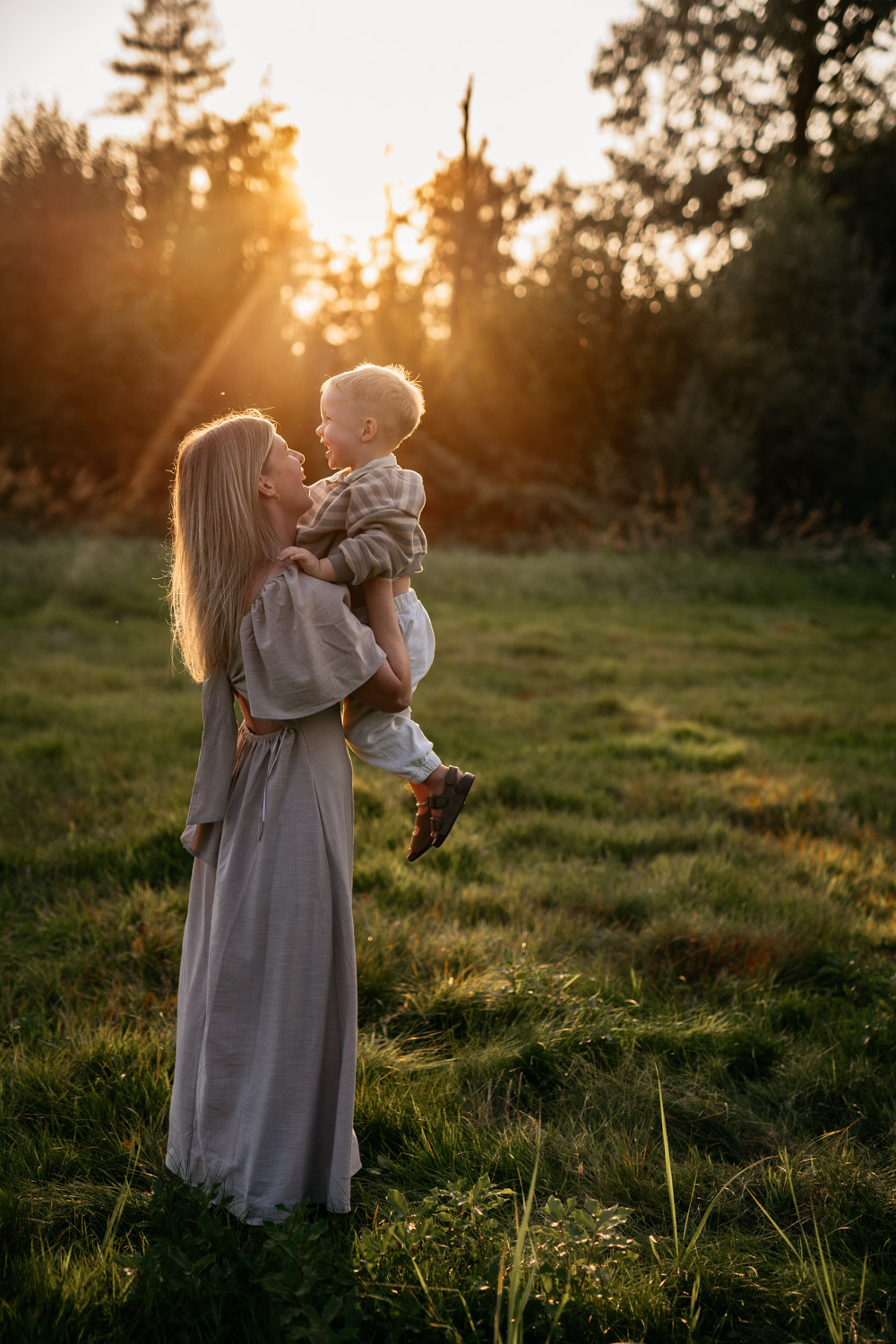 a woman holding a child in a field