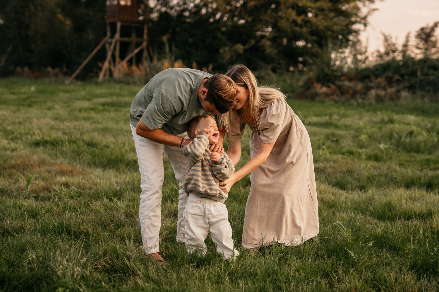 a man and woman tickle a child