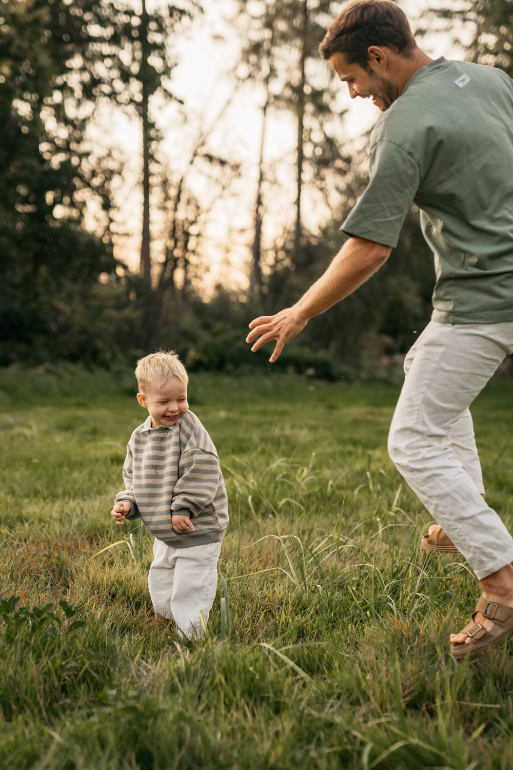 a man and child playing in a grassy field