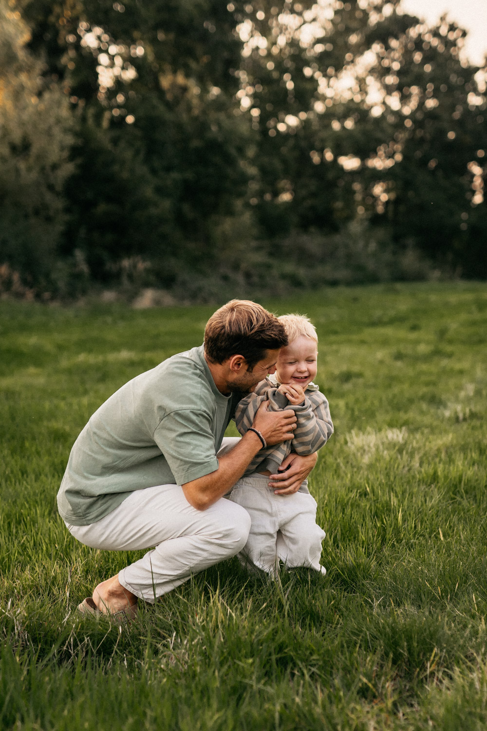 a man holding a child in a grassy field