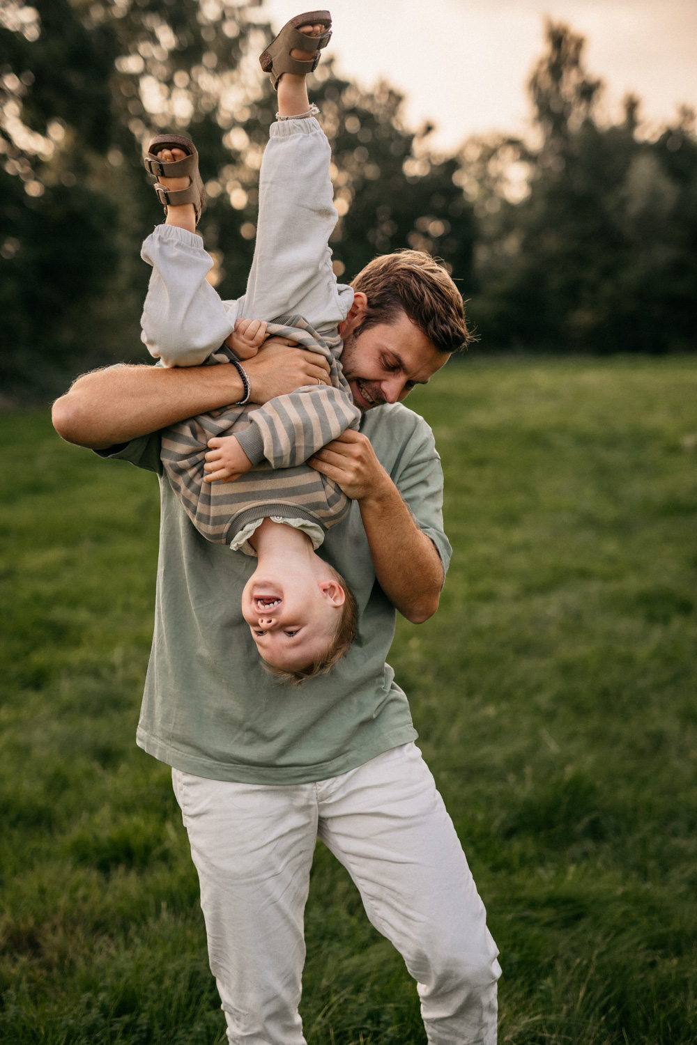 a man holding a baby upside down