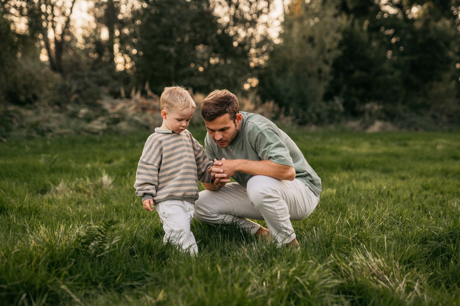 a man and child in a grassy field