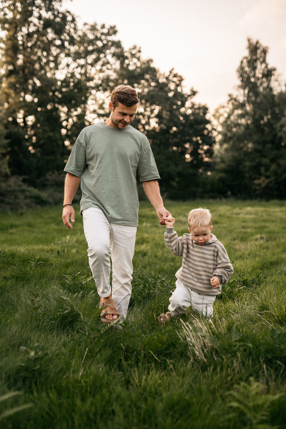 a man and child walking in grass