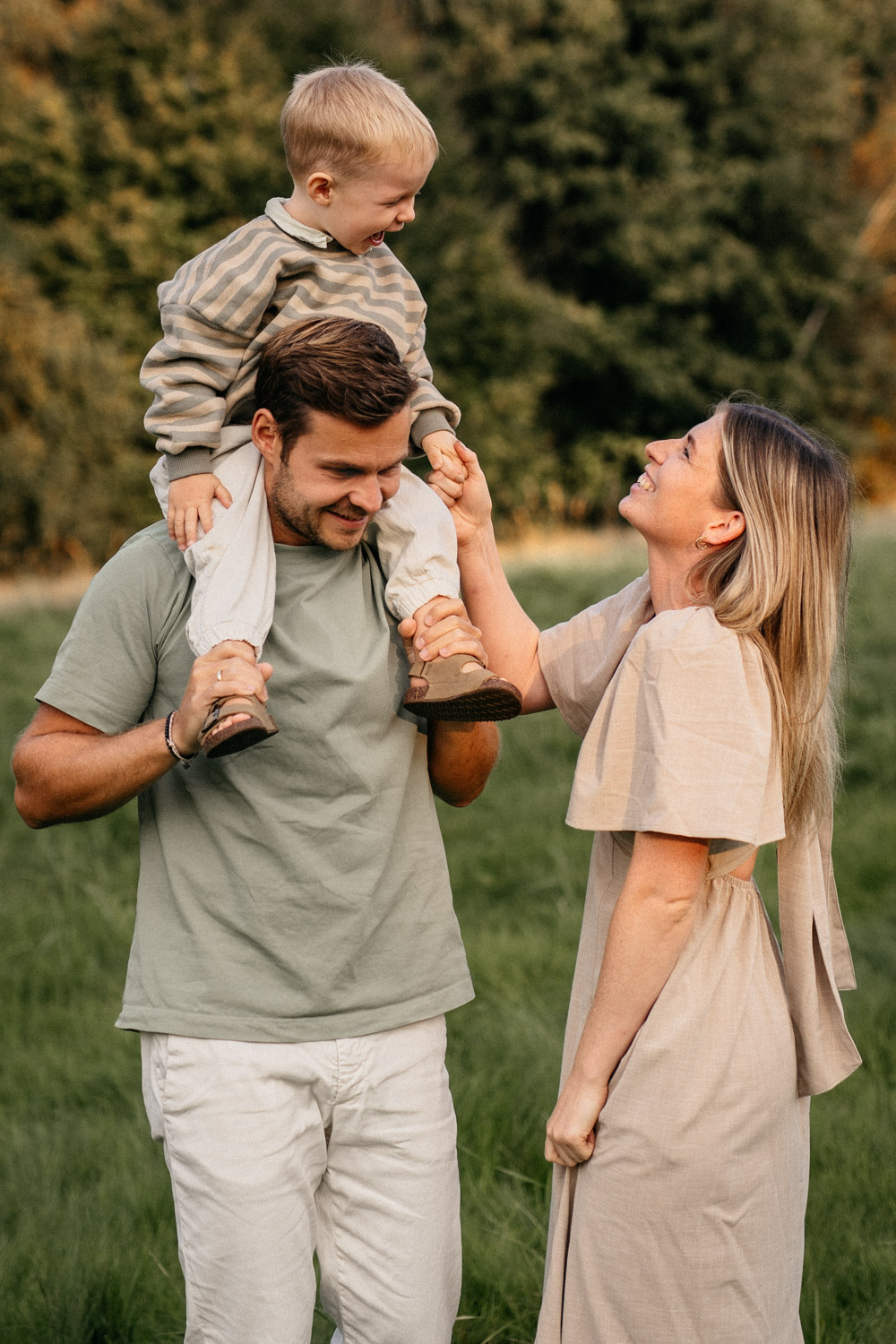 a man and woman holding a child on their shoulders