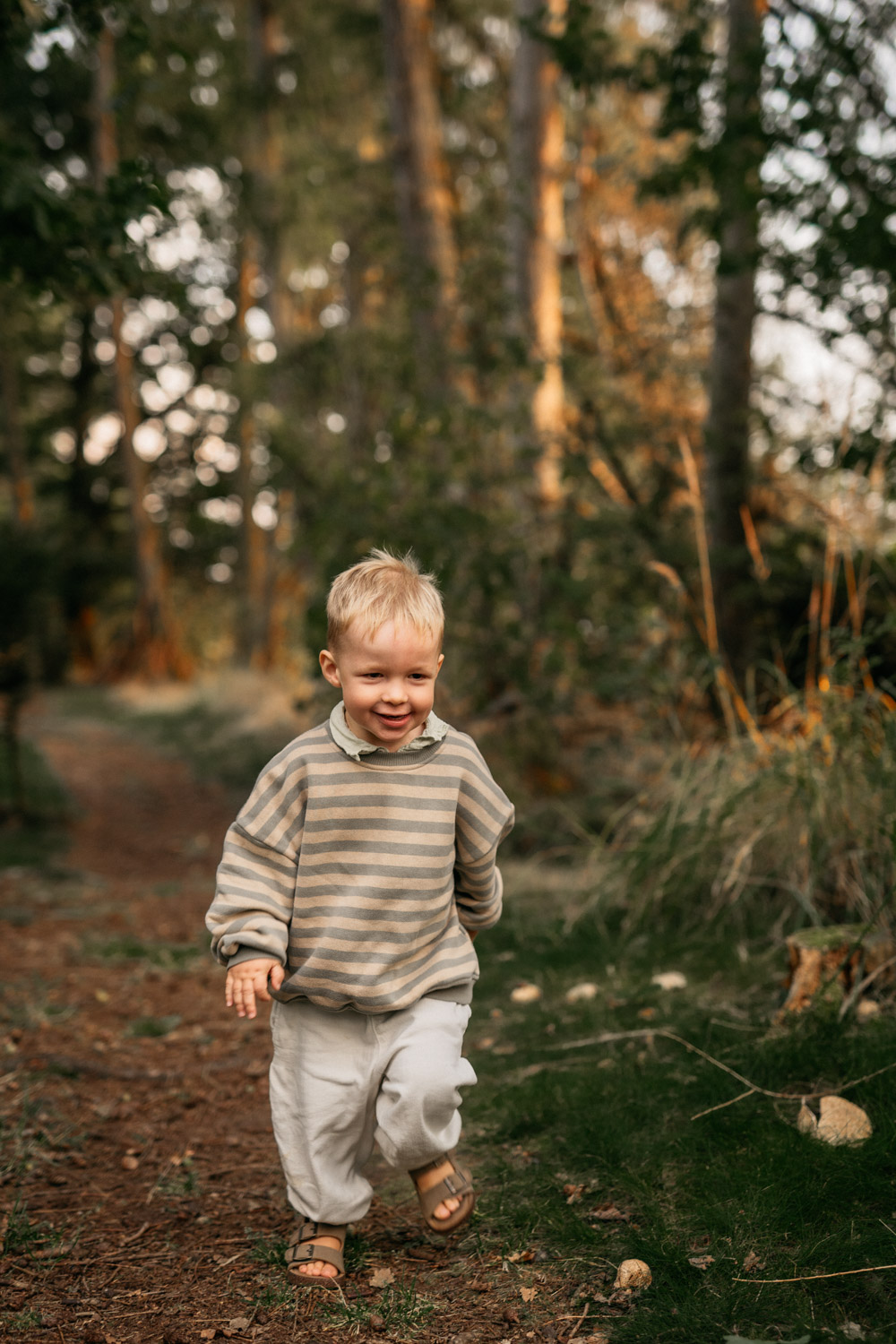 a boy running on a path in the woods